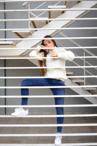 Woman looking at camera while sitting on staircase