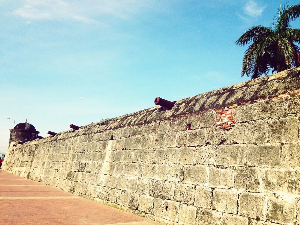 architecture, building exterior, built structure, low angle view, sky, stone wall, wall - building feature, history, brick wall, clear sky, sunlight, steps, old, day, stone material, outdoors, blue, shadow, wall, religion