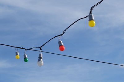 Low angle view of light bulbs against sky