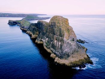 Rock formations by sea against sky