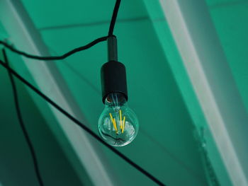 Close-up of light bulb hanging from ceiling