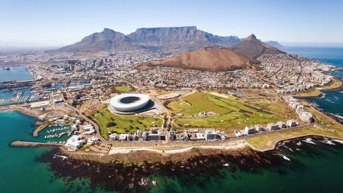 Aerial view of cape town stadium amidst sea and mountains in city