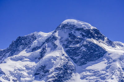 Scenic view of snowcapped mountains against clear blue sky