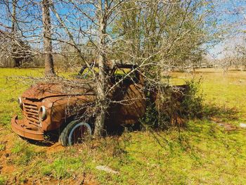 Abandoned car on field against clear sky