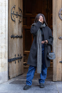 Low section of woman standing against wall