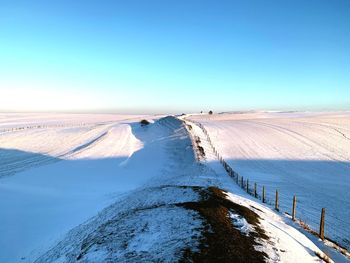 Scenic view of snowcapped landscape against clear blue sky