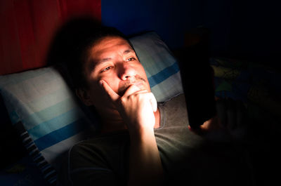 Portrait of man lying on sofa at home