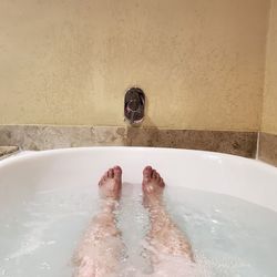 Low section of person in bathtub