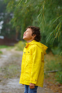 Boy looking away while standing outdoors