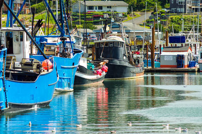 Boats moored in sea by cityscape