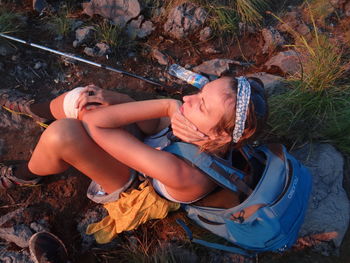 High angle view of female hiker sitting on ground
