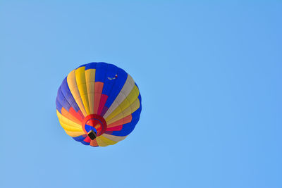 Low angle view of hot air balloon against clear blue sky