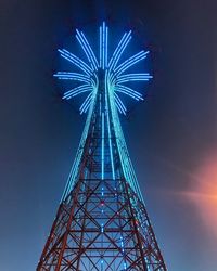 Low angle view of illuminated ferris wheel against sky at night