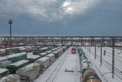 Railway station in winter. on the tracks are electric trains and freight cars