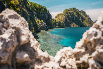 Scenic view of rocks on sea shore against sky