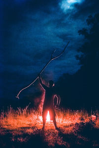 Man on illuminated field against sky at night