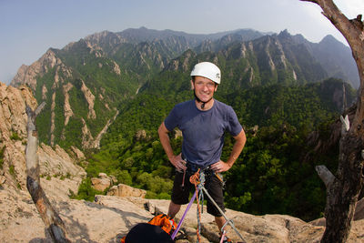 Portrait of smiling man standing on mountain