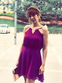 Portrait of smiling woman wearing purple dress