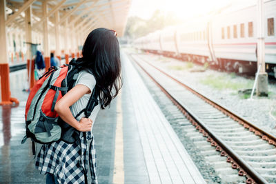 Woman standing on railroad station platform