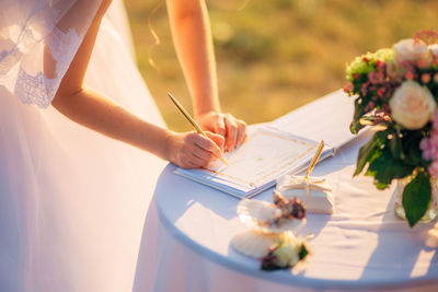 Close-up of woman signing certificate at marriage