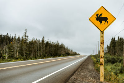 Road sign against sky