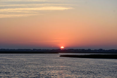 Scenic view of sea against romantic sky at sunset