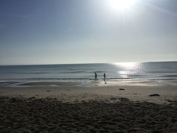 Scenic view of beach against sky on sunny day