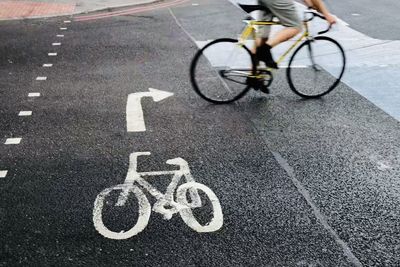 Low section of man cycling on street in city