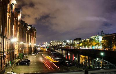 Cars on road in city against sky at night