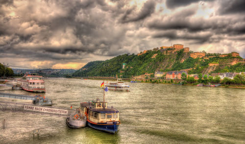 Boats in sea against storm clouds