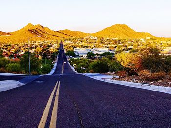 Road by mountains against clear sky