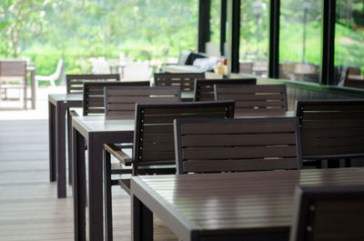 Empty chairs and table by window