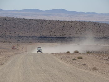 Scenic view of desert road against sky