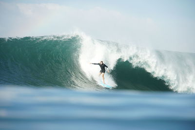 Man surfing in sea against sky