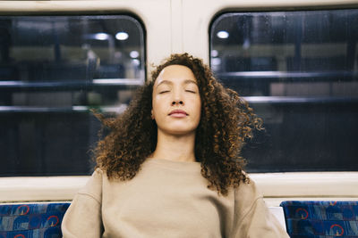 Woman with eyes closed relaxing in subway train