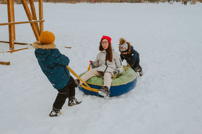 Children ride a tubing. mom and children ride a tubing. outdoor winter games for the whole family. 