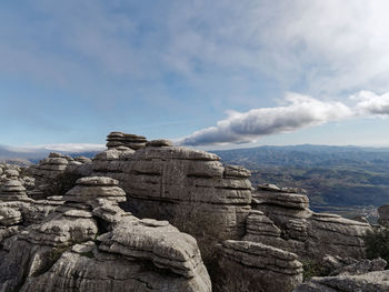 Rock formations against cloudy sky