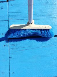 High angle view of broom on blue porch during sunny day