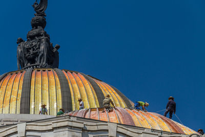 Low angle view of statue against clear blue sky