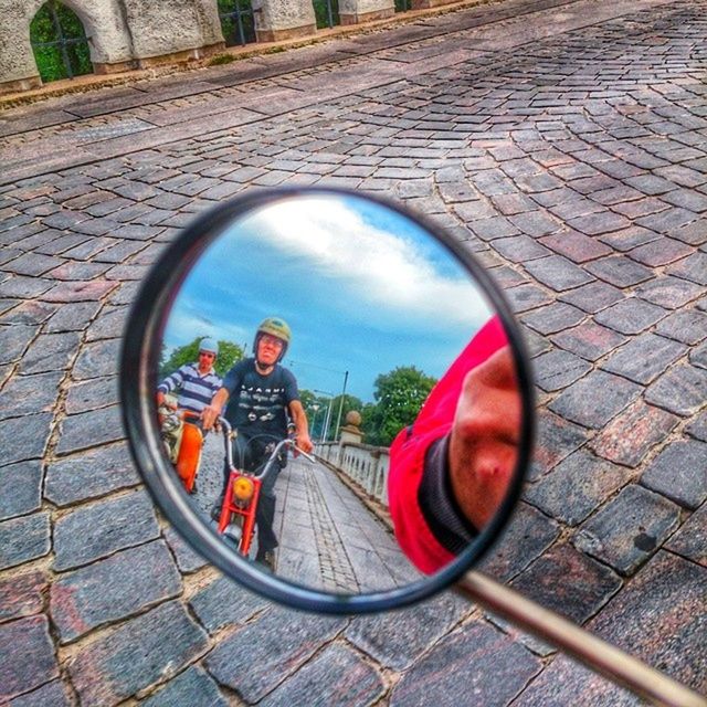 circle, transportation, water, reflection, street, outdoors, day, no people, red, high angle view, cobblestone, sky, close-up, cloud - sky, geometric shape, mode of transport, built structure, road, paving stone, land vehicle