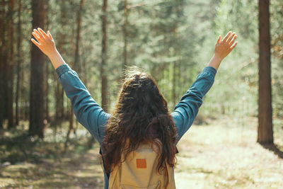 Rear view of backpacker hiking in forest