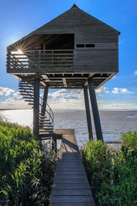 Built structure by sea against sky