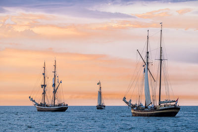 Ship sailing on sea against sky during sunset