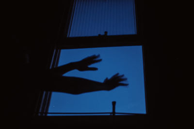 Shadow of person hand on glass window at home