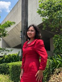 Happy woman standing against plants