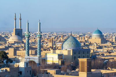 Aerial view of buildings in city against clear sky