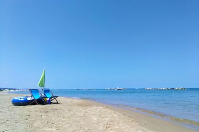 Sailboat on beach against clear blue sky