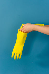 Close-up of woman hand against blue background