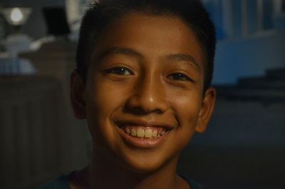Close-up portrait of boy smiling at night