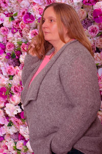 Model in a cardigan against a rose background